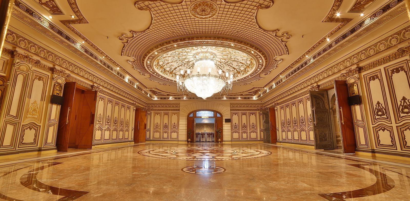 Interiors of Rang Mahal hall A grand hotel suite with an opulent red and white decor, large bed, and seating area, reflecting a traditional style at Sitara Luxury Hotel in Hyderabad near Ramoji Film City.
