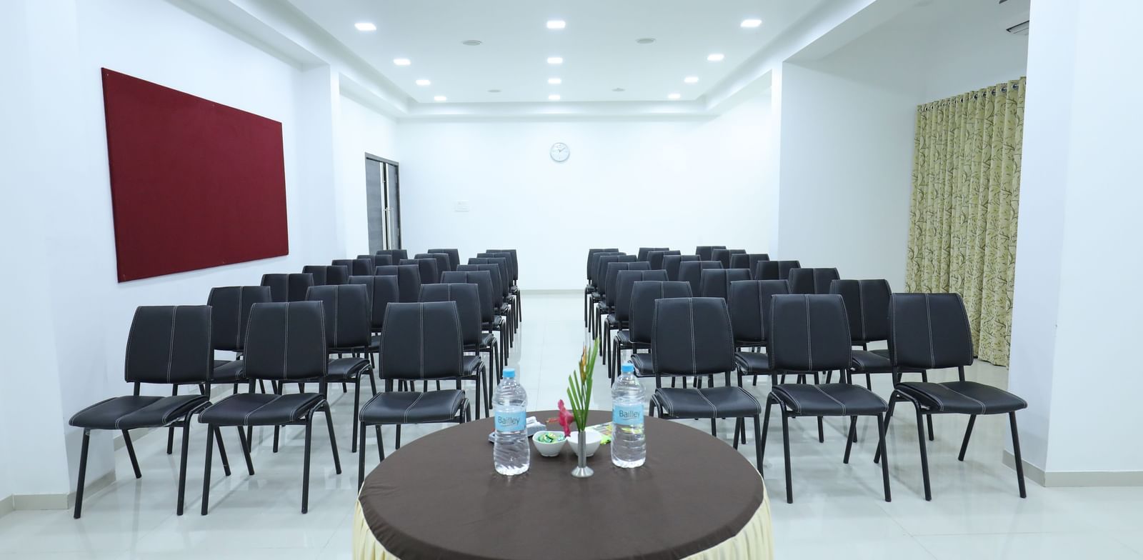 A conference room at Imperial Grande with rows of black chairs facing a small round table in the foreground.