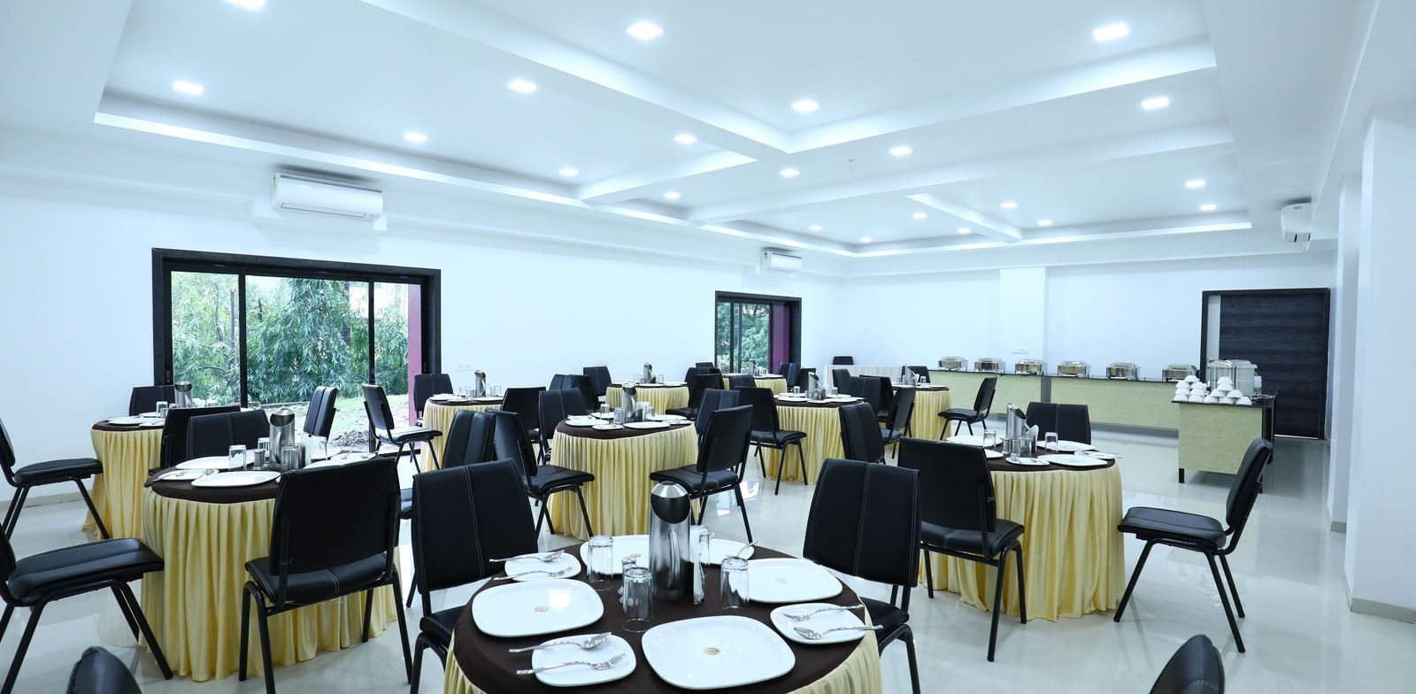 A well-lit dining space at Imperial Grande, featuring a clustered seating arrangement and windows offering a view of the outdoors.