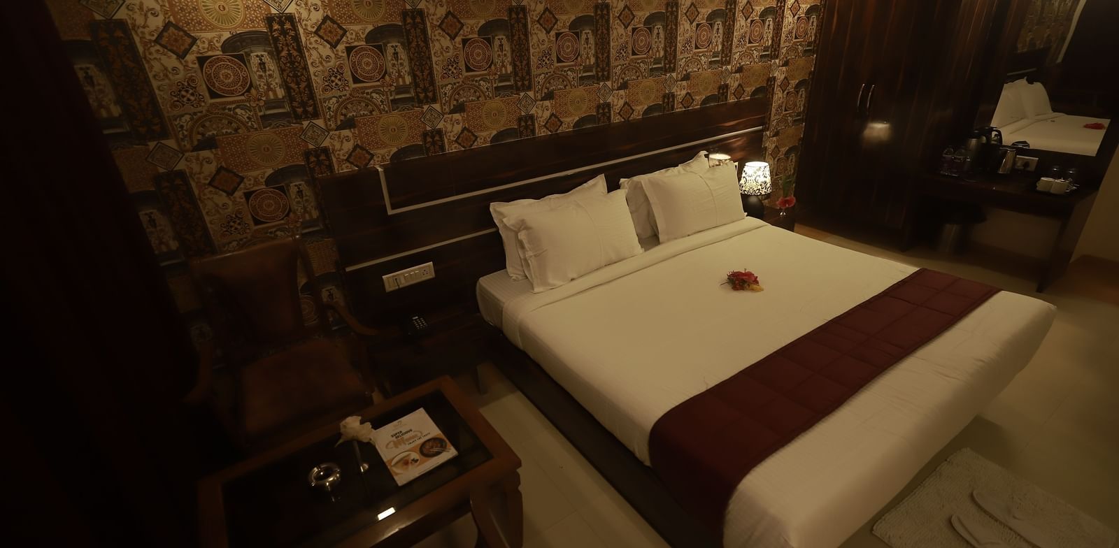 A Deluxe Room of Mountview Resort furnished with a king size bed, a wardrobe, bedside tables, and a seating area.