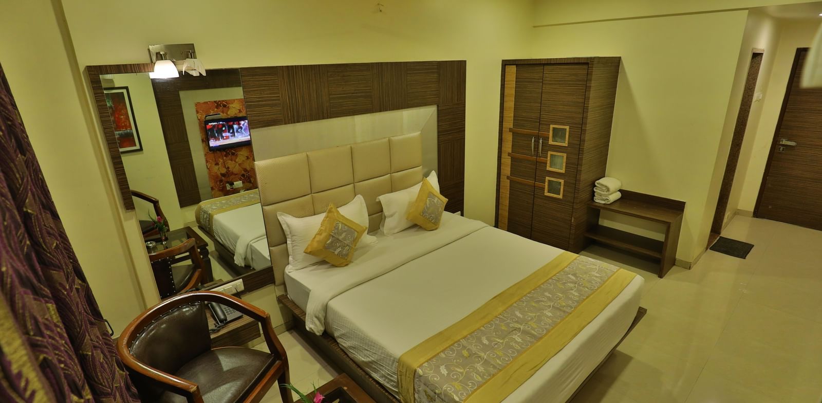 An expansive view of a well-appointed hotel room featuring a bed, seating, and contemporary decor - Retreat Heritage, Lonavala
