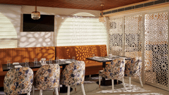 An image of our restaurant with colourful patterned chairs - Deventure Sarovar Portico, Patel Nagar