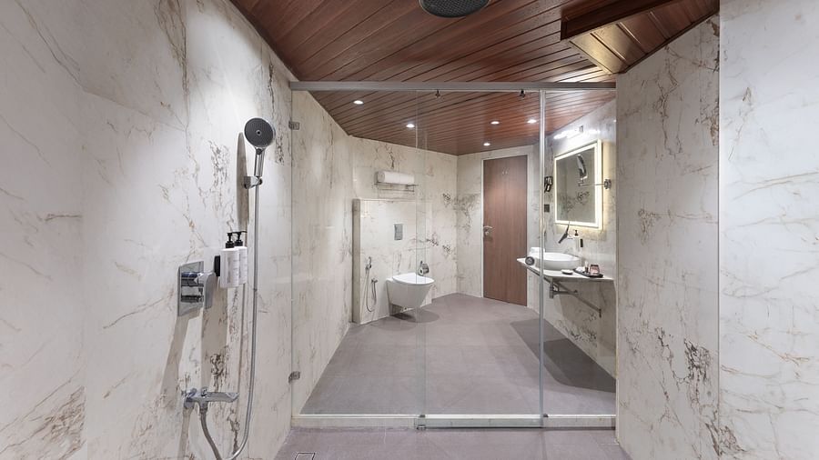  Luxurious bathroom with marble walls, rain shower, and spacious vanity area at Clarks Inn Suites, Hyderabad