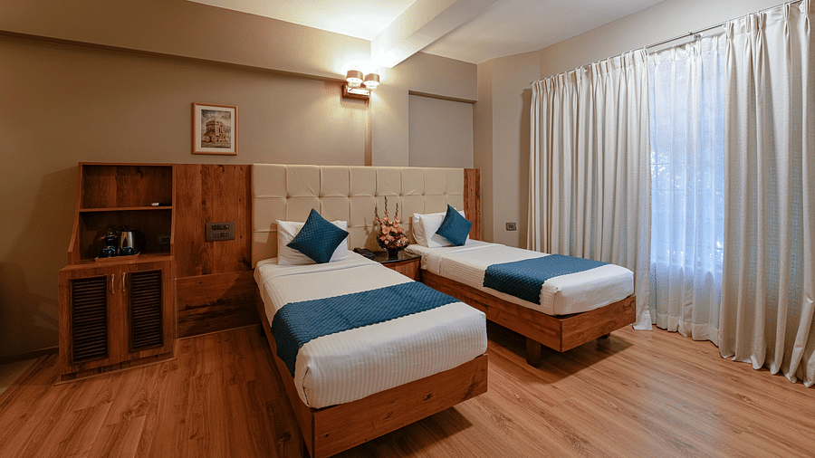 An image of our spacious Deluxe Room with twin beds and elegant lighting - Cross Roads Inn, Bengaluru