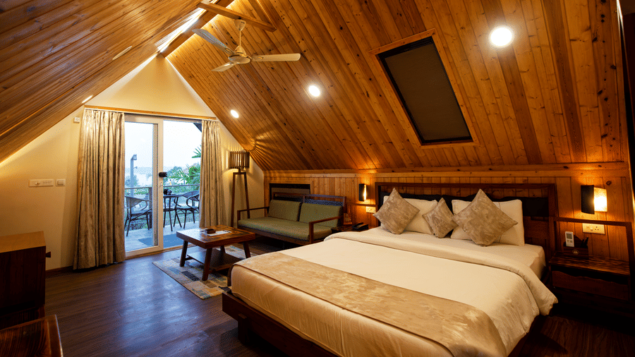 Well-lit bedroom with a balcony, a queen size bed, and conical ceiling at Hotel Sonar Bangla, Taki.