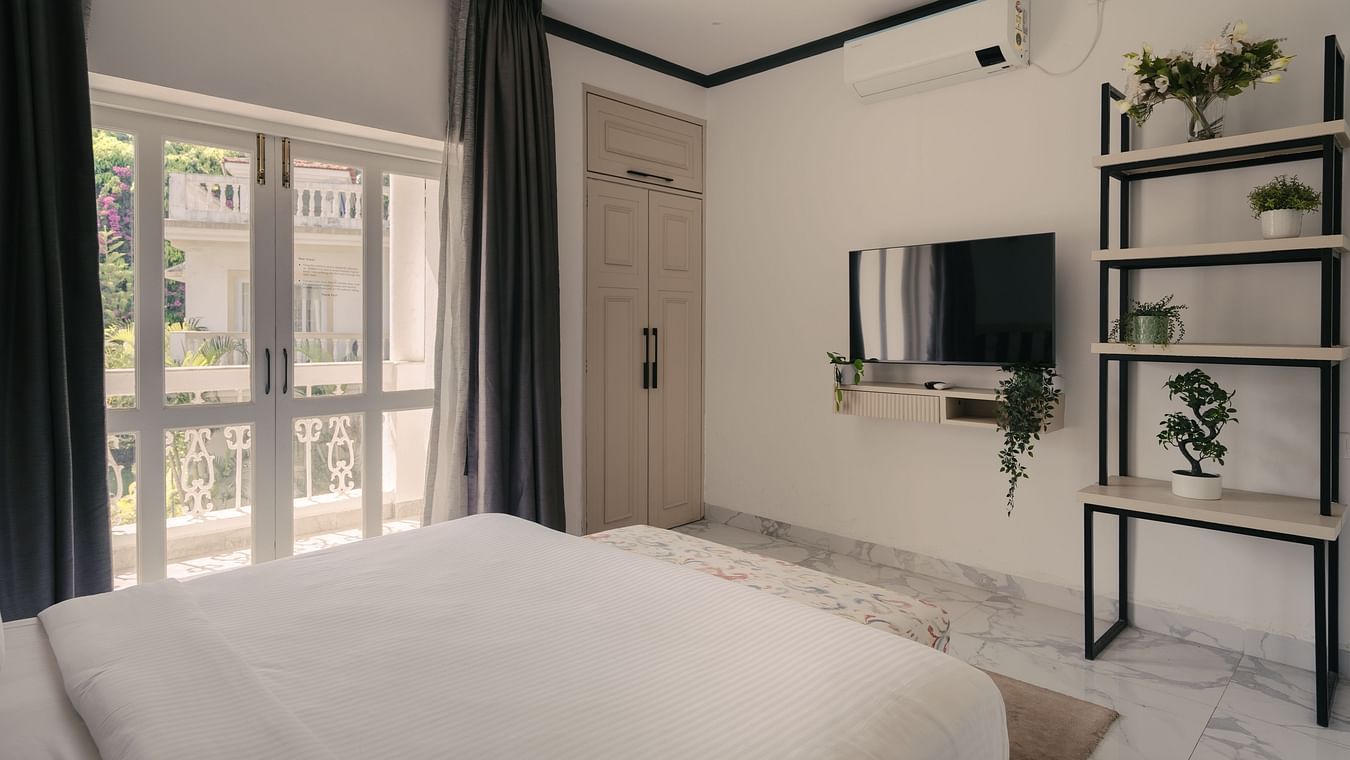 A well-appointed bedroom with a private balcony at Three BHK Premium Villa, Richmonde Ananta Elite, Goa.