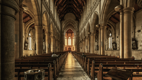 interior view of a cathedral with benches and an altar in view in the distance