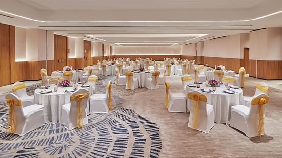 A well lit banquet hall where tables and chairs are aligned at The Dukes Retreat.