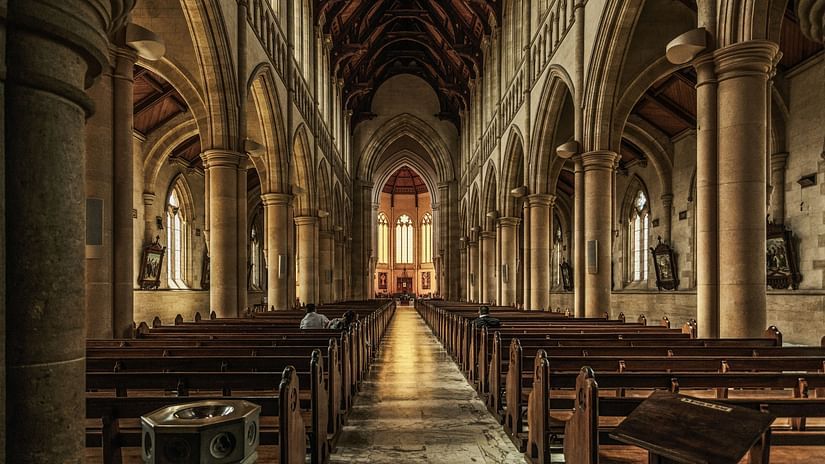 interior view of a cathedral with benches and an altar in view in the distance