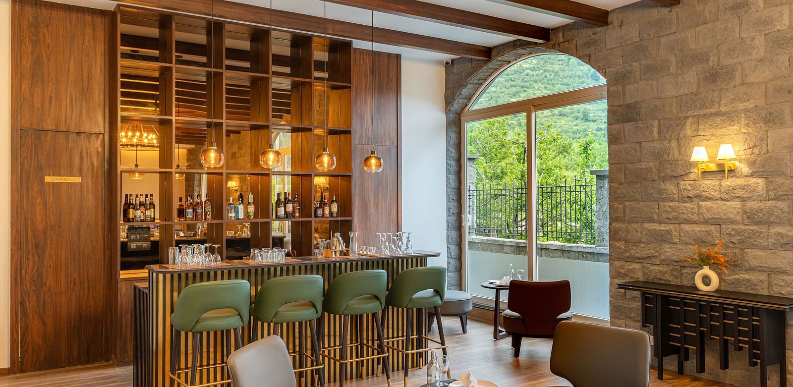 Elegant bar space with large windows and comfy seating at Nivasana Manali.