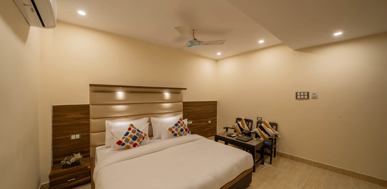 Spacious, minimalist hotel room with a minimalist design, wooden headboard, and a ceiling fan - Perfectstayz Premium at Har Ki Pauri Road (Ganga Heights)