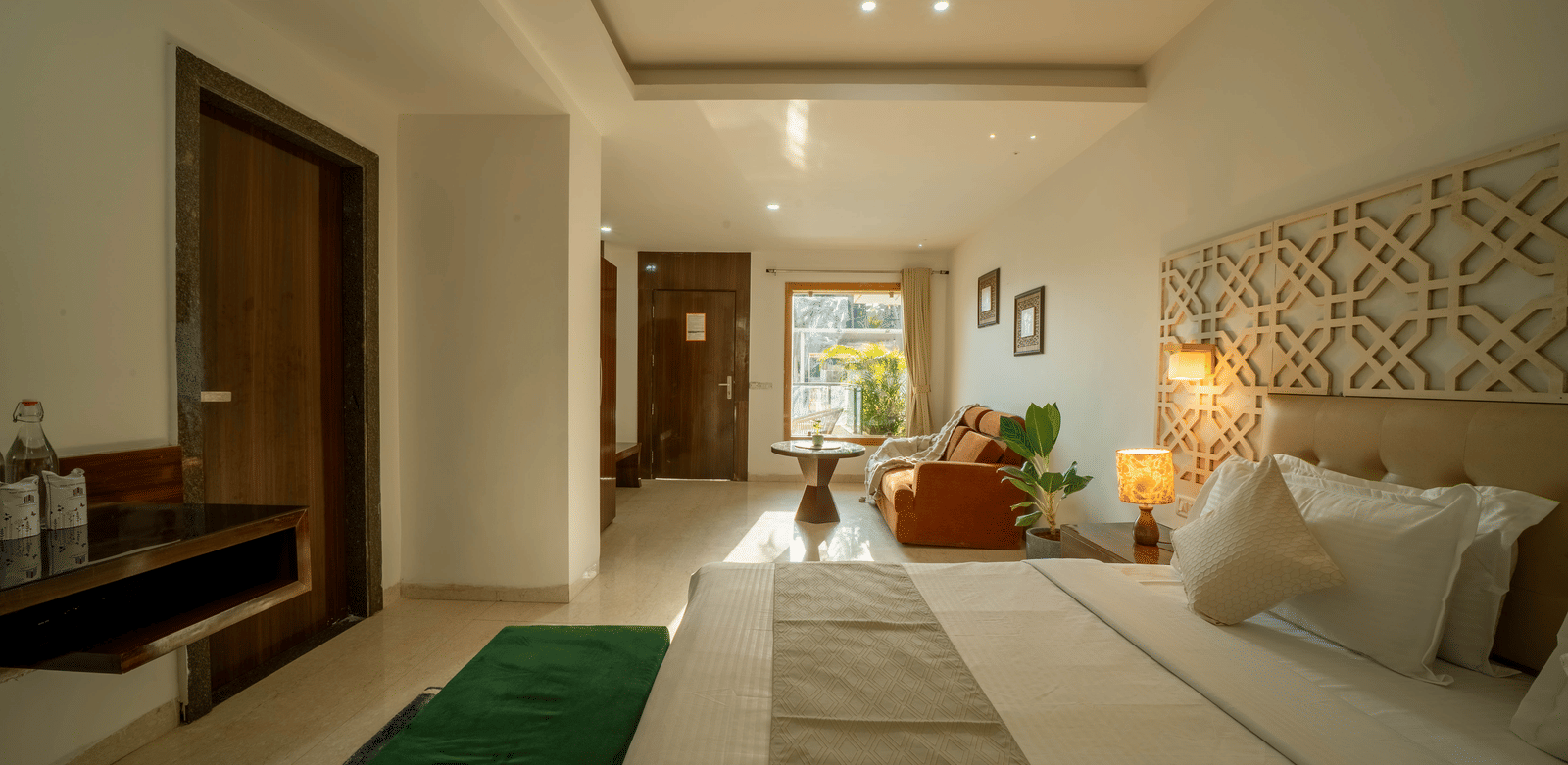 An elegant and luxurious room at Perfectstayz Premium Goa Continental with a king size bed, stylish lighting, and green accent rugs.