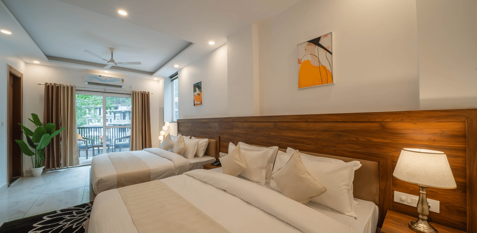 A room with 2 beds, a wooden headboard, a lamp on a bedside table, and a picture frame on the wall in Perfectstayz Premium Mystic Falls, Rishikesh.