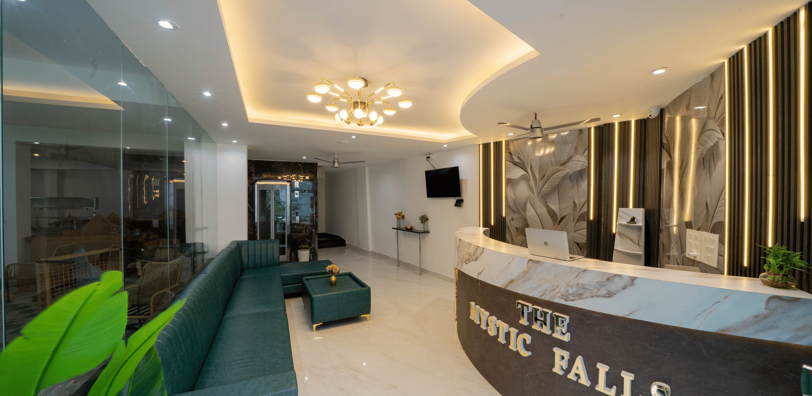 A reception area with a desk, a sign with letters, and seating along the wall in Perfectstayz Premium Mystic Falls, Rishikesh.