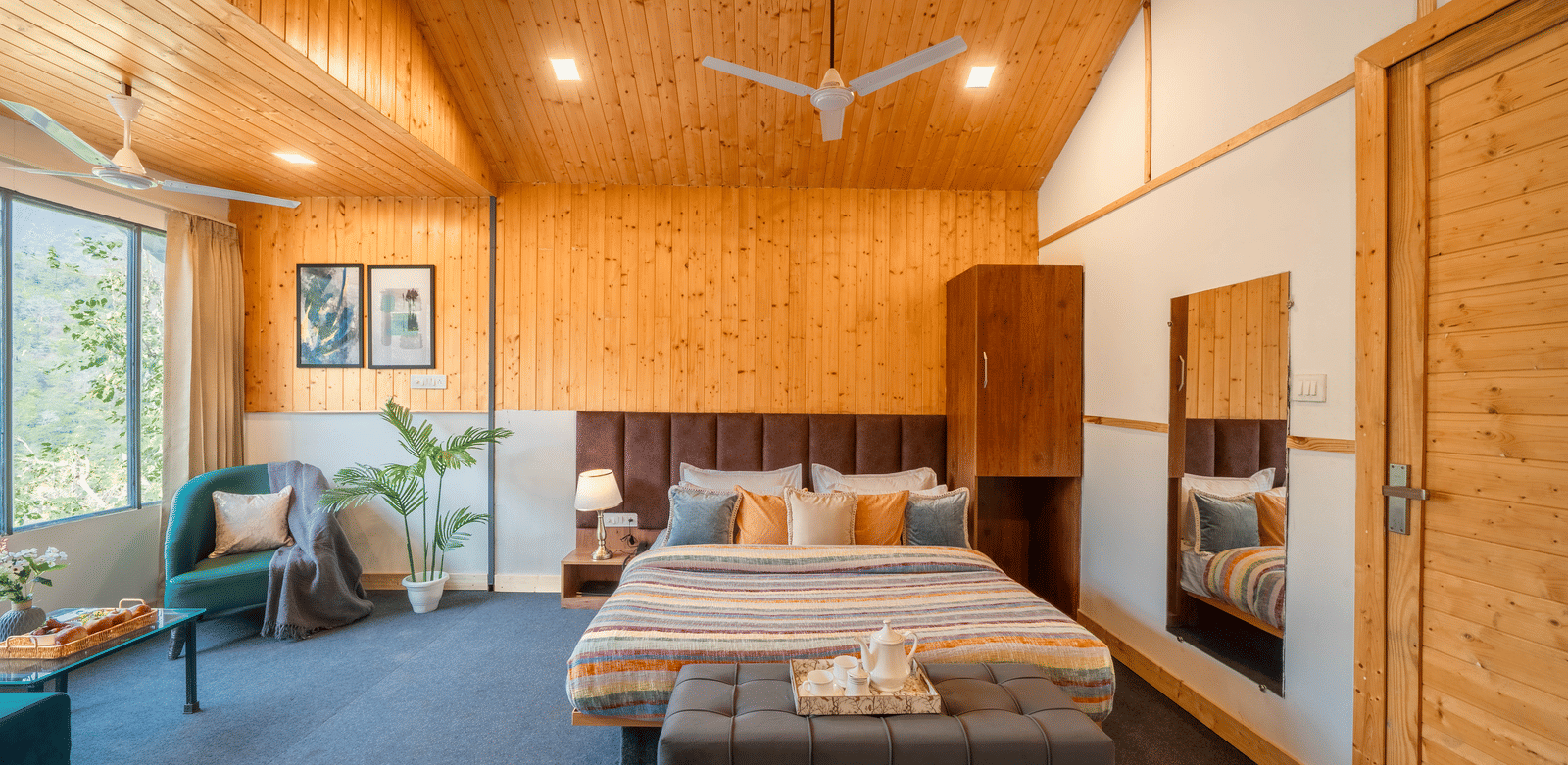 A room at Perfect Stayz The Jungle Resort presents a bed, a bedside table, and a separate seating arrangement.