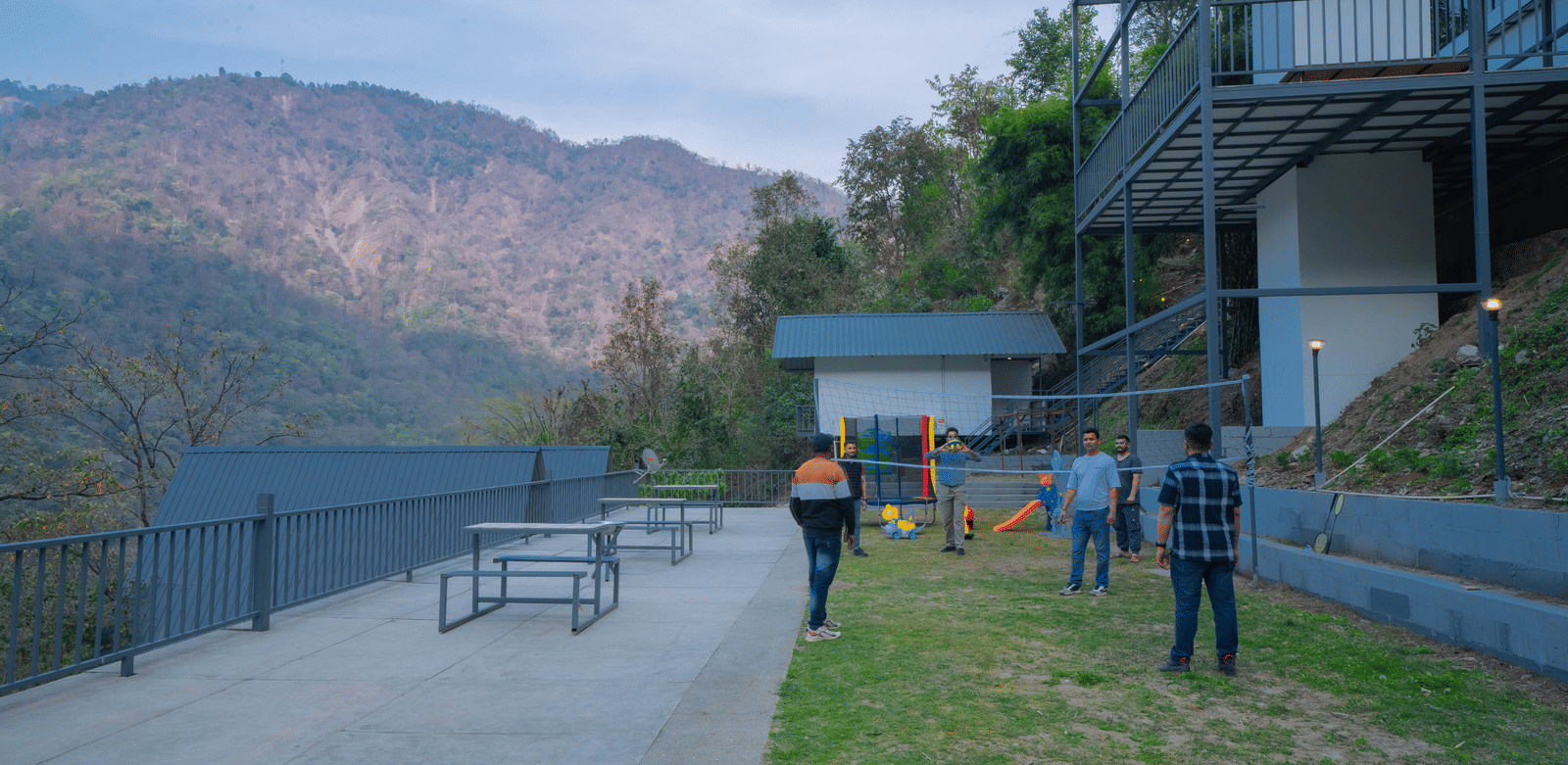 People walk on a lawn near the buildings of Perfect Stayz The Jungle Resort.