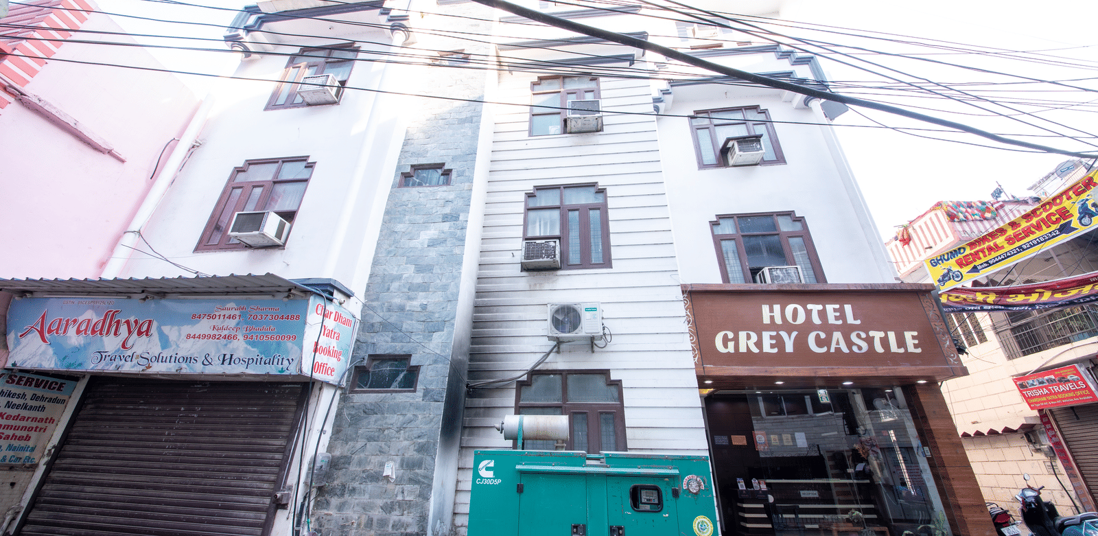 Exterior view of a multi-storey building, with many electrical lines passing through the front - Perfectstayz Value Grey Castle, Haridwar 