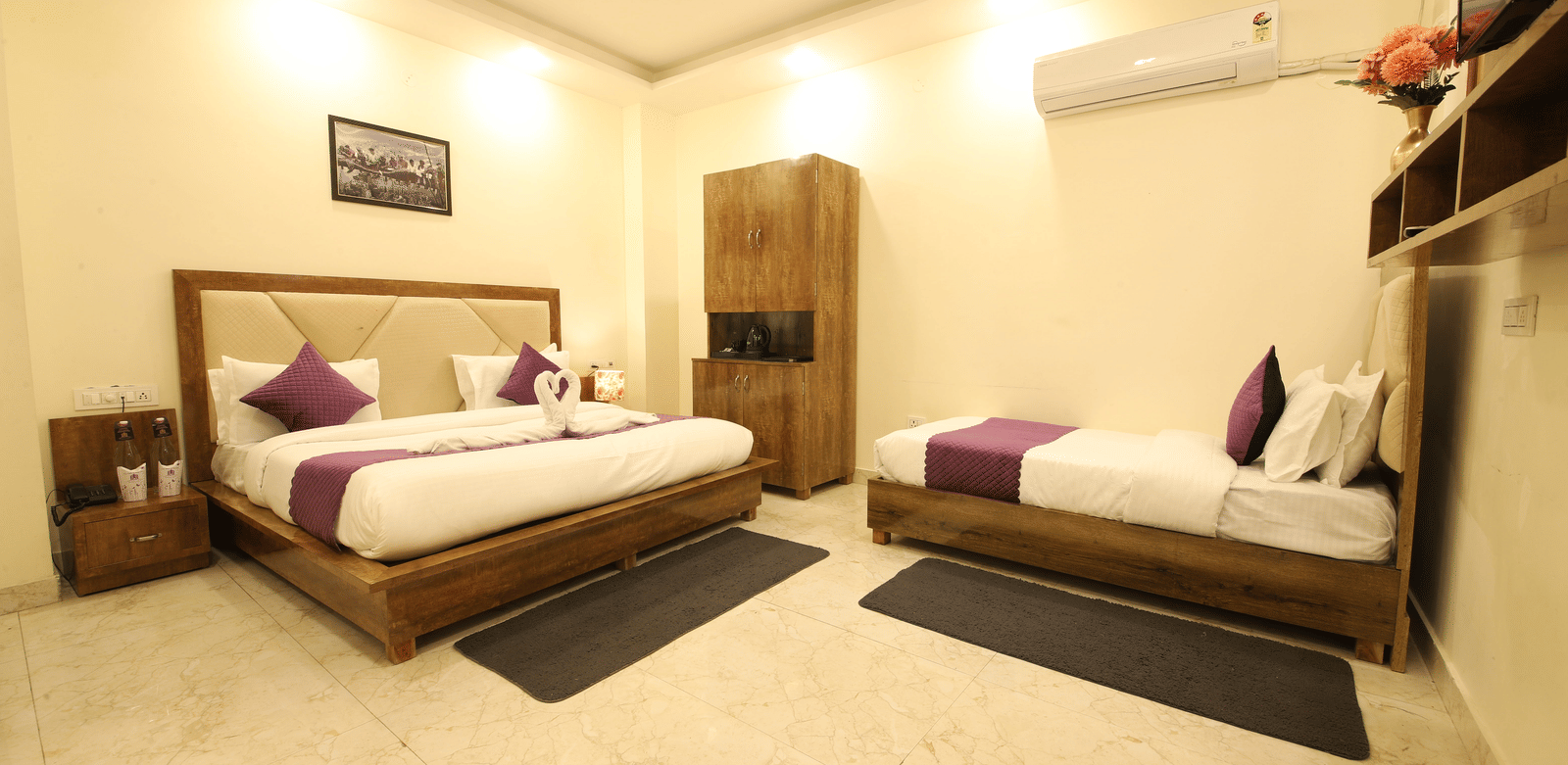 A hotel room, featuring 2 beds with white linens and purple accent runner, a dark wooden headboard and frame, nightstands, and beige tiled floor | Perfectstayz Value Hills, Rishikesh