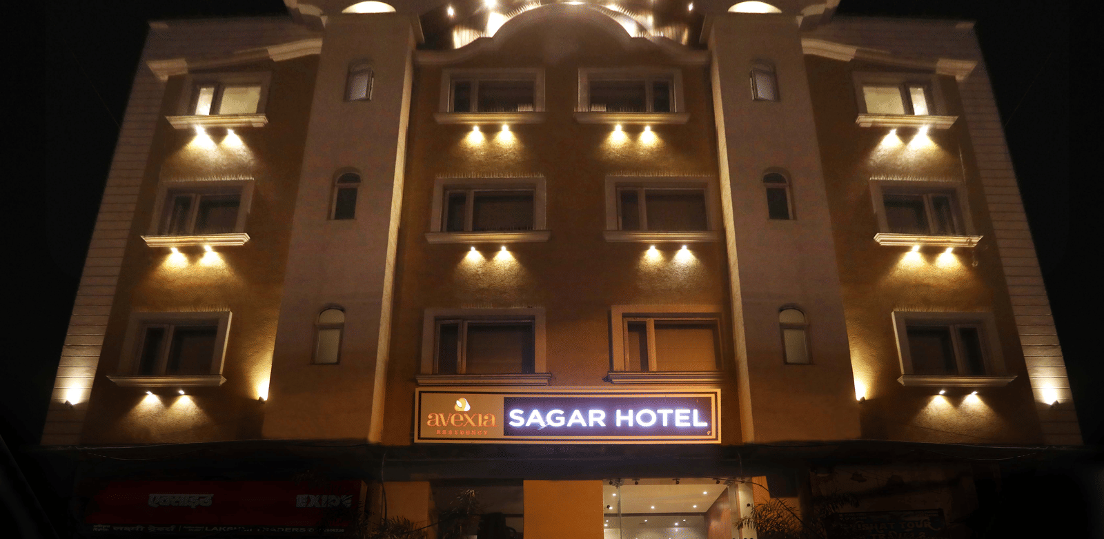 The exterior of a multi-storey hotel building illuminated at night, with a sign that reads 'SAGAR HOTEL' | Perfectstayz Value Sagar