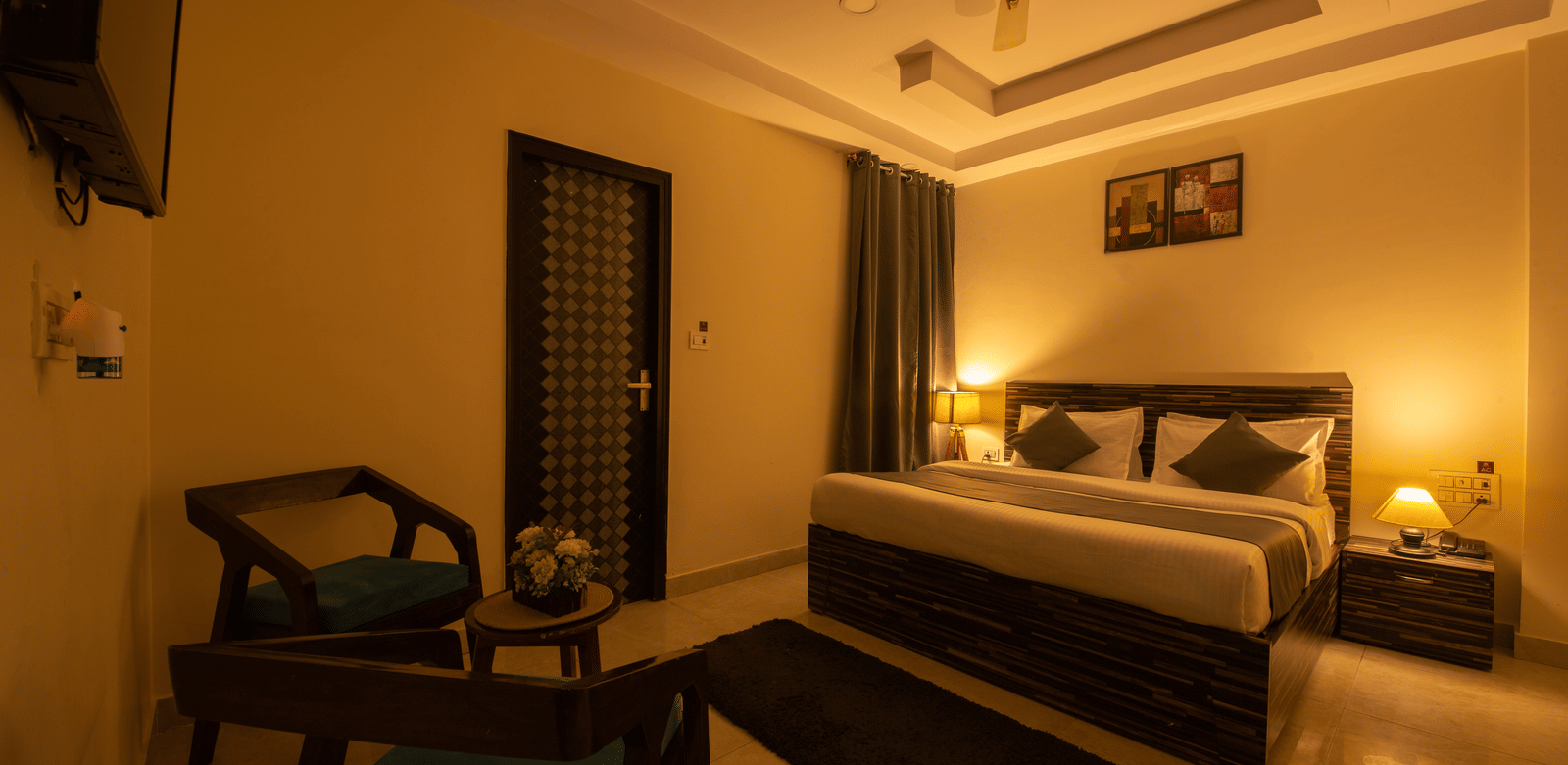 Spacious hotel room with ambient lighting and seating area - Perfectstayz Value Umra Grace, Haridwar