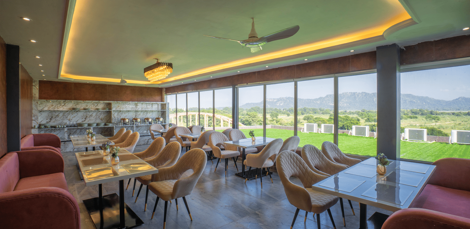 The bright, modern dining area at Sukoon by the Ganges features floor-to-ceiling windows with lovely outdoor views.