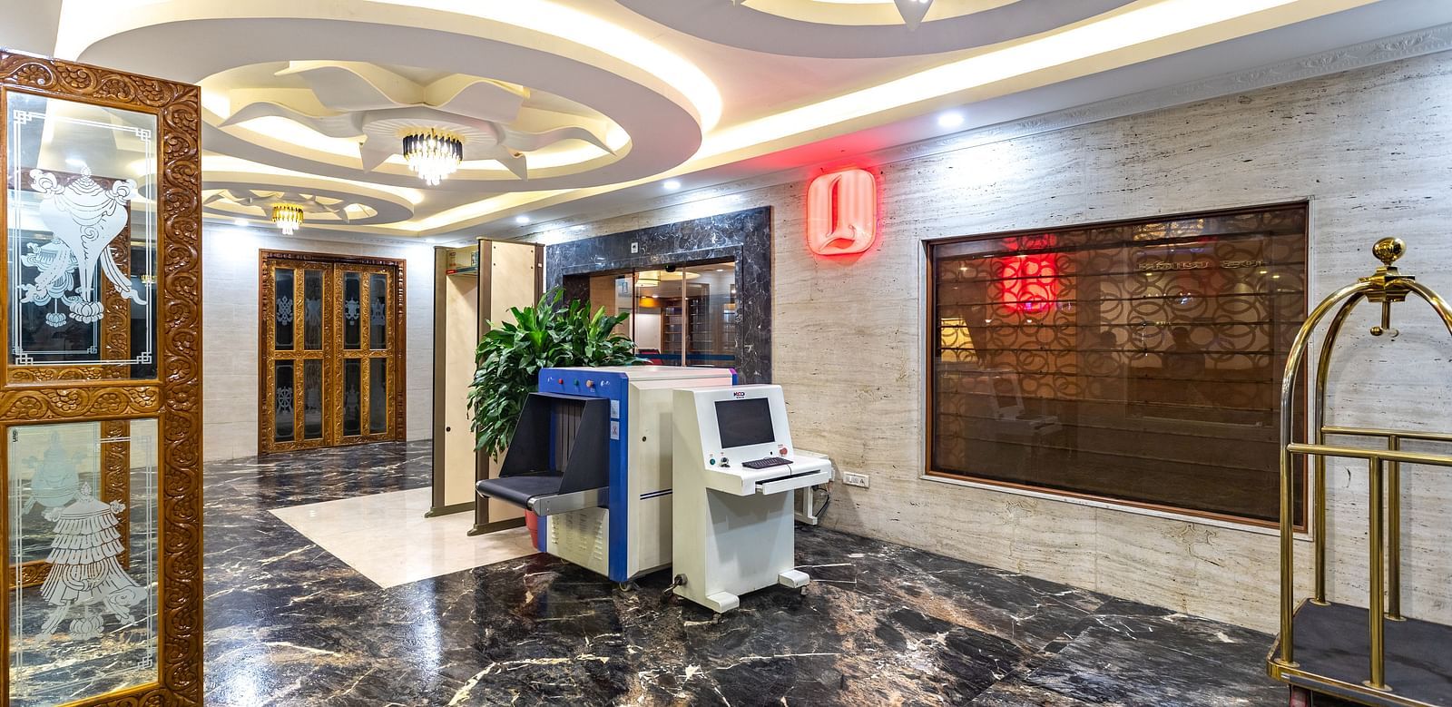 Elegantly designed lobby at Diamond Palace Lords Plaza with marble flooring, ornate ceiling, and security equipment.