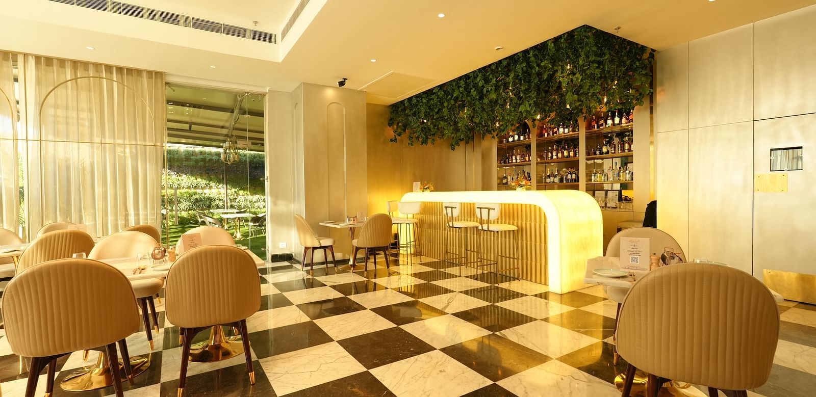 Elegant café-style dining area with beige chairs and sleek flooring - Grand Plaza Lords Inn Jammu