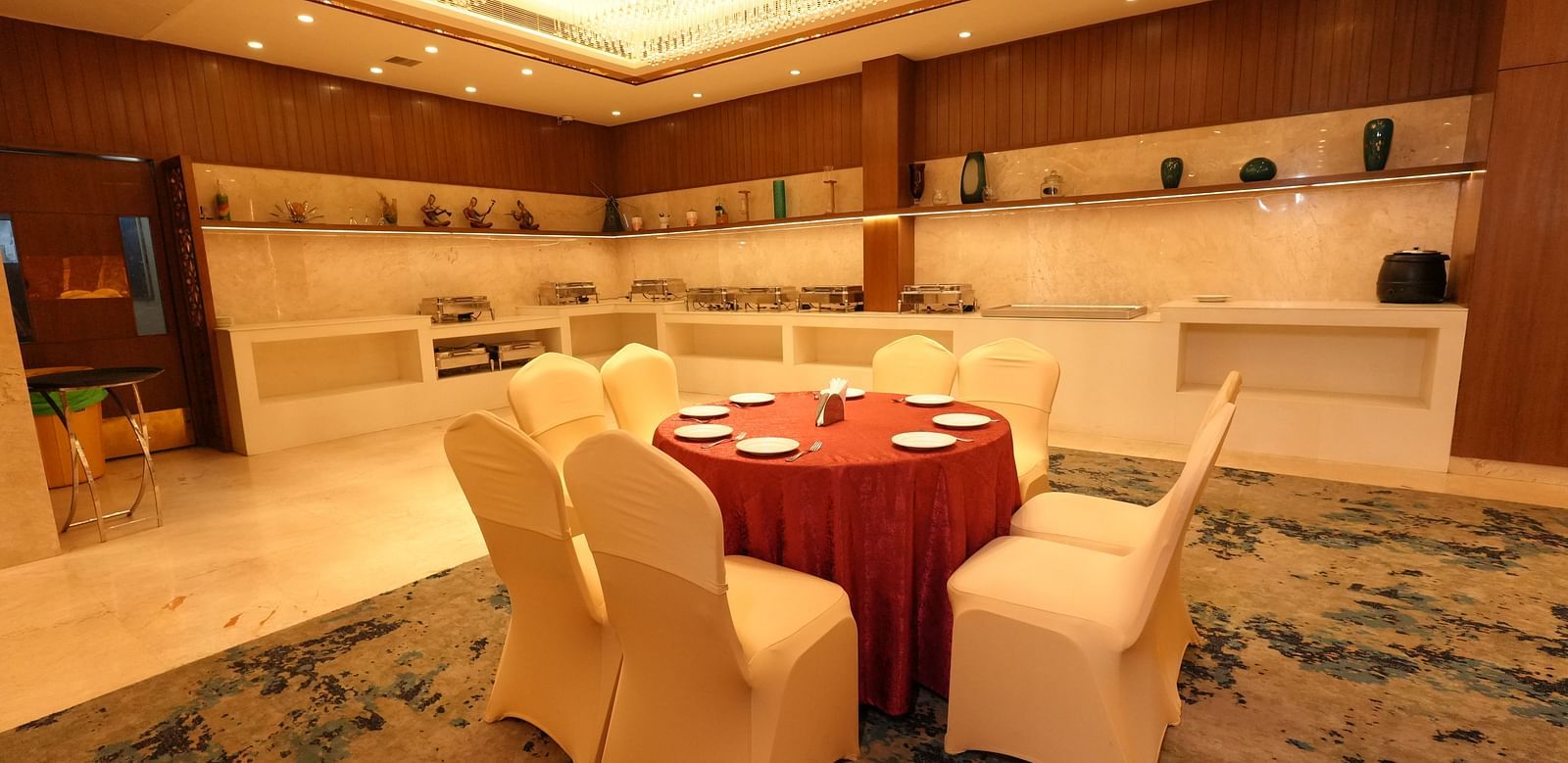 Dining area setup with a round table and cushioned chairs - Grand Plaza Lords Inn Jammu