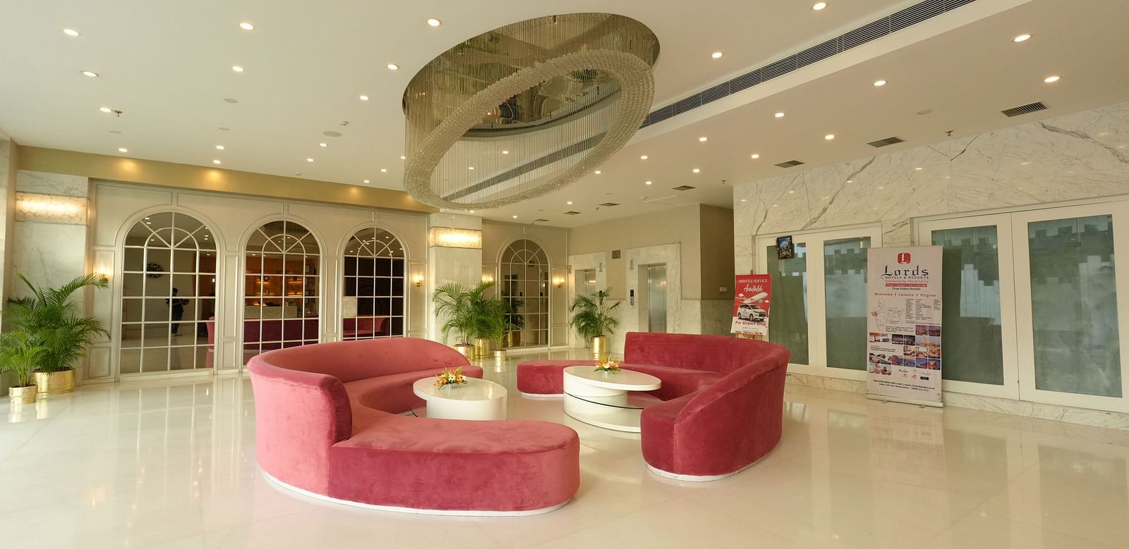 Hotel lobby with modern décor and curved pink seating - Grand Plaza Lords Inn Jammu