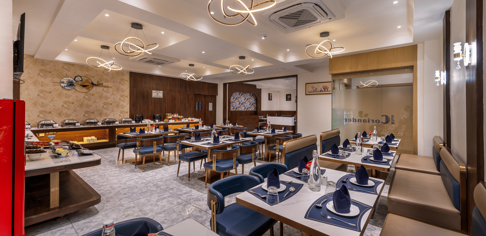 In-house dining area with neatly arranged tables and bright interiors at Lords Studio Inn, Jamnagar.