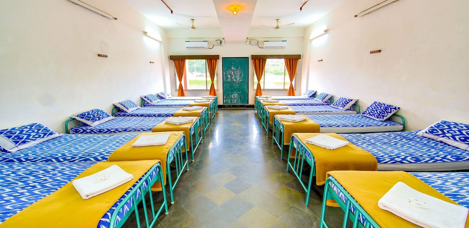 A dormitory with pillows and blankets on each bed at Sahara - Cozy Dormitories in Hyderabad.