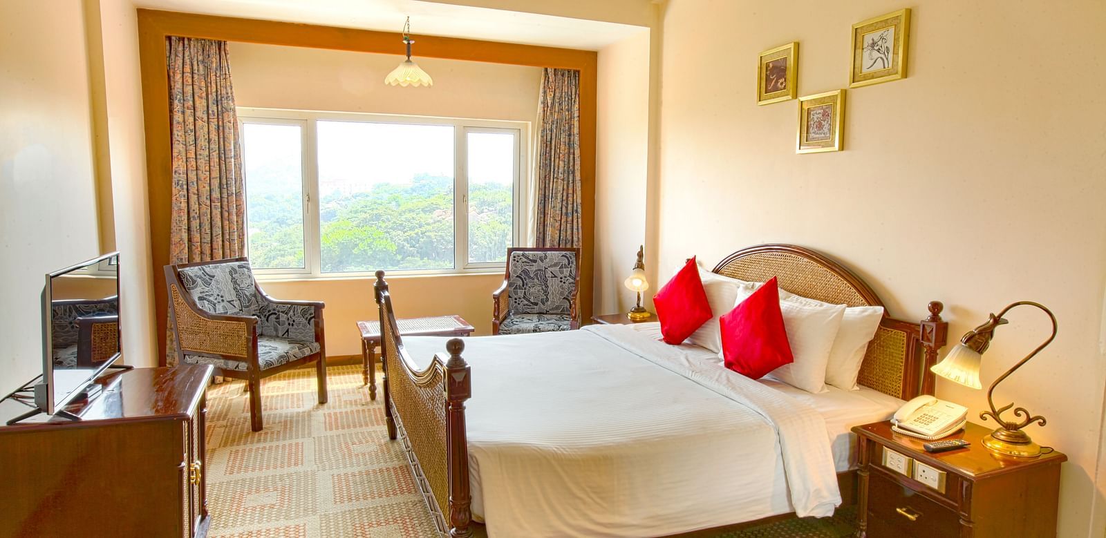 A cozy hotel room with a large window, offering a scenic view and featuring modern furnishings.