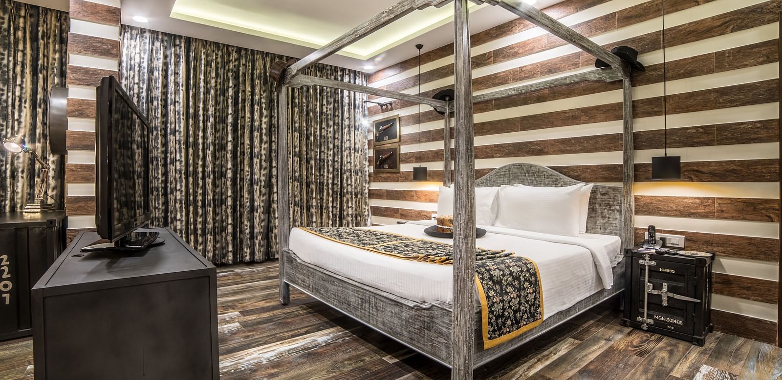 An opulent hotel room with a four-poster bed, striped walls, and dark wood furniture creating a luxurious atmosphere A grand hotel suite with an opulent red and white decor, large bed, and seating area, reflecting a traditional style at Sitara Luxury Hotel
