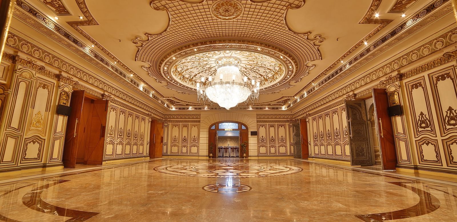 Interiors of Rang Mahal hall A grand hotel suite with an opulent red and white decor, large bed, and seating area, reflecting a traditional style at Sitara Luxury Hotel in Hyderabad near Ramoji Film City.