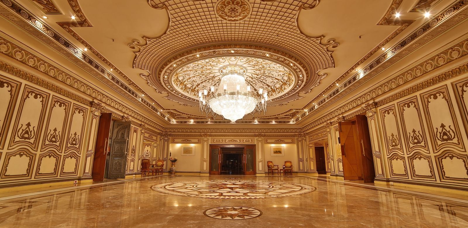  Interiors of Rang Mahal hall A grand hotel suite with an opulent red and white decor, large bed, and seating area, reflecting a traditional style at Sitara Luxury Hotel in Hyderabad near Ramoji Film City.