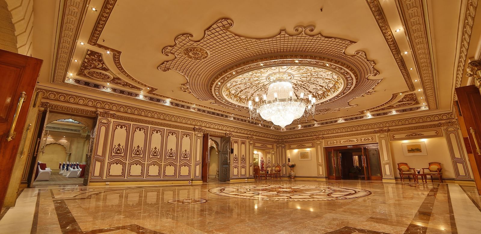  Interiors of Rang Mahal hall A grand hotel suite with an opulent red and white decor, large bed, and seating area, reflecting a traditional style at Sitara Luxury Hotel in Hyderabad near Ramoji Film City.