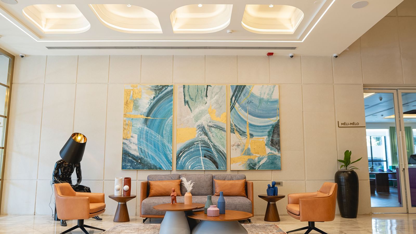 Lobby at KertelSuites, featuring a cosy sofa, a round coffee table, and an elegant ceiling with stylish lighting.