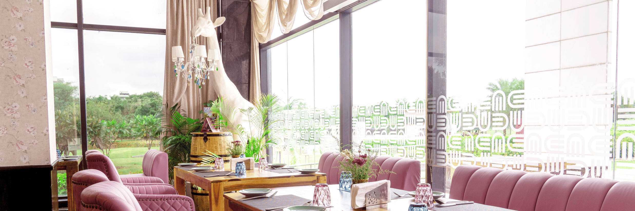 Seating arrangements inside On Kourse at Karma Lakelands with floor to ceiling windows.