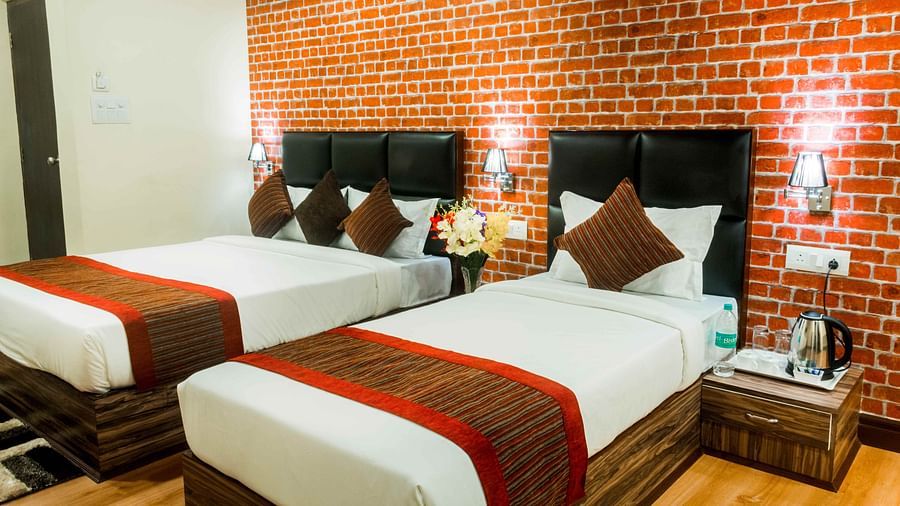 An image of the deluxe room with twin bed, bed side tables, and other modern amenities - Ecotel Tin Tin, Bijanbari