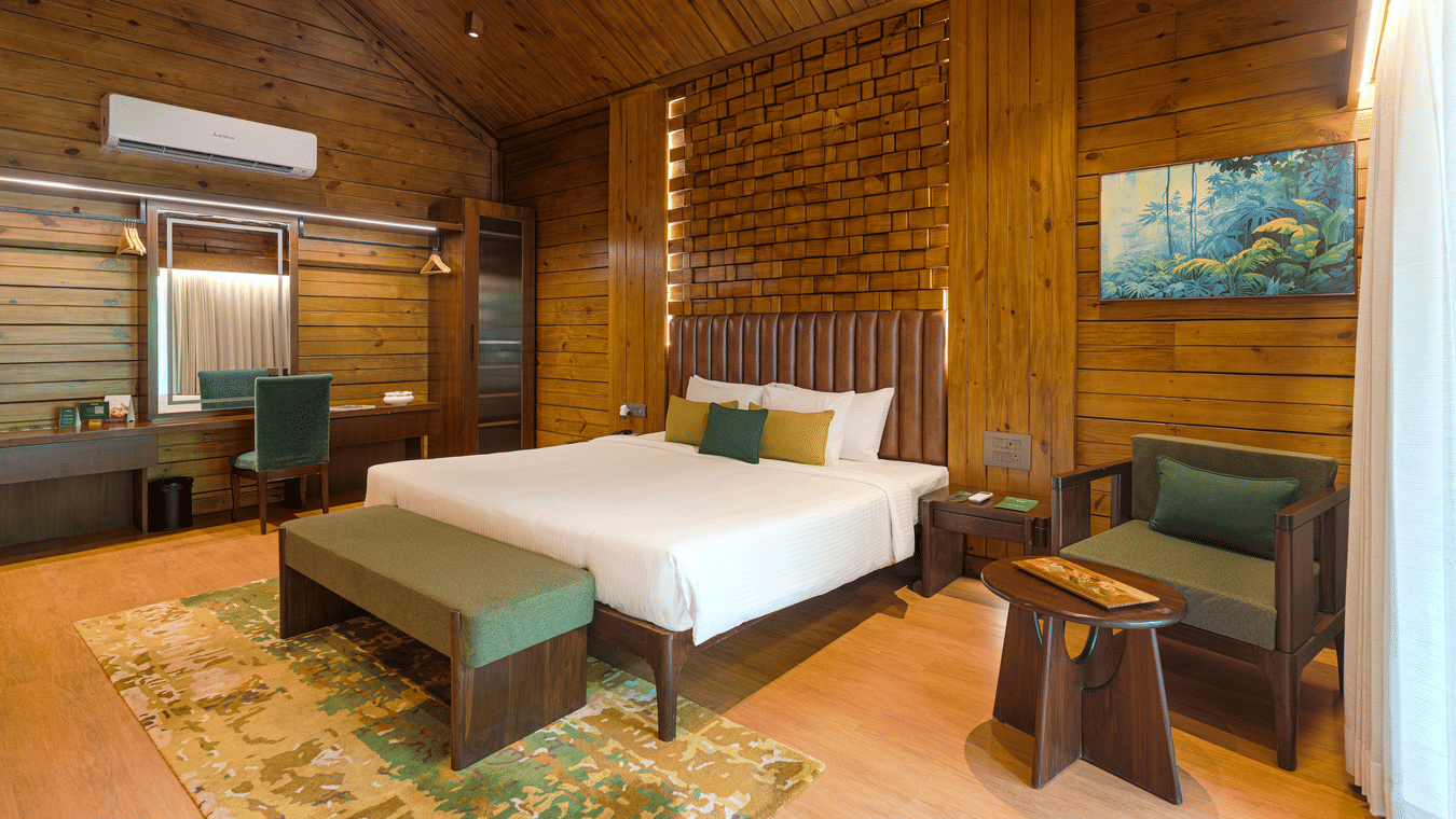 Premium Wooden Cottage with Bathtub bedroom with a bed, armchair and wooden ceiling at The Ananta Udaipur.