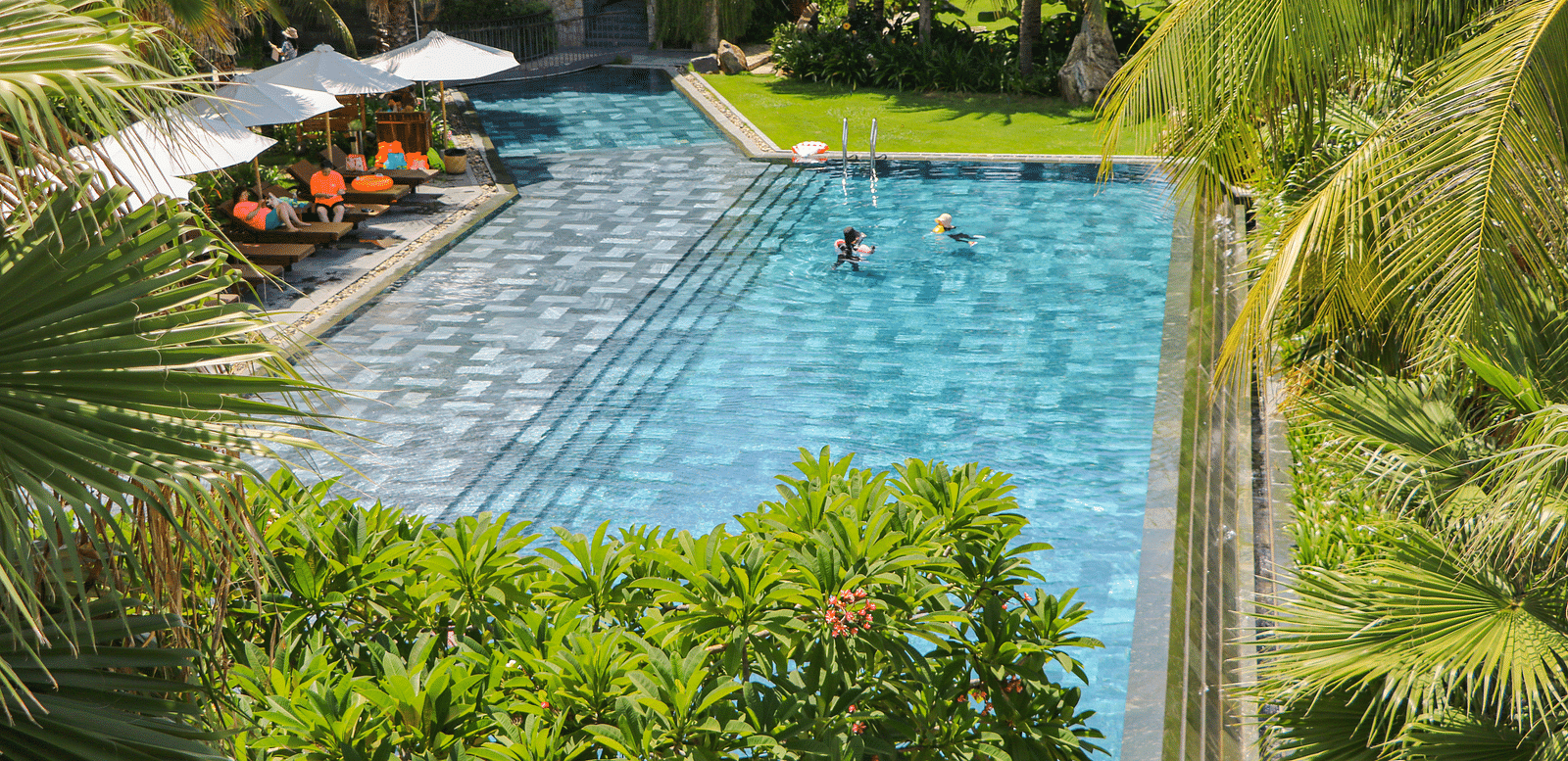 An image showcasing the pool at our resort with people enjoying a swim during a sunny day - Alibu Resort Nha Trang