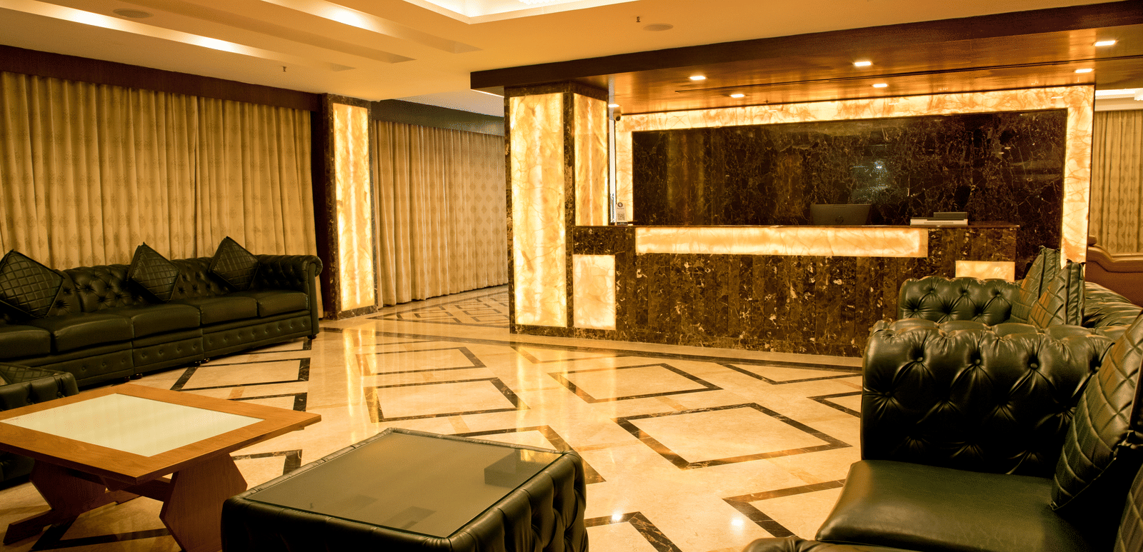 A hotel lobby at Benzz Park Chennai with comfortable seating areas, stylish decor, and ornate flooring.