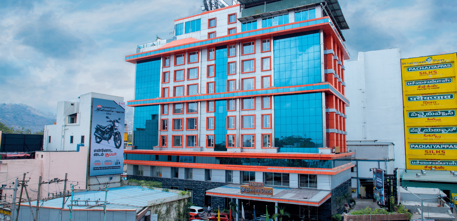Facade shot of Benzz Park, Vellore, featuring the entrance on the bottom of the building along with a cloudy sky in the background.