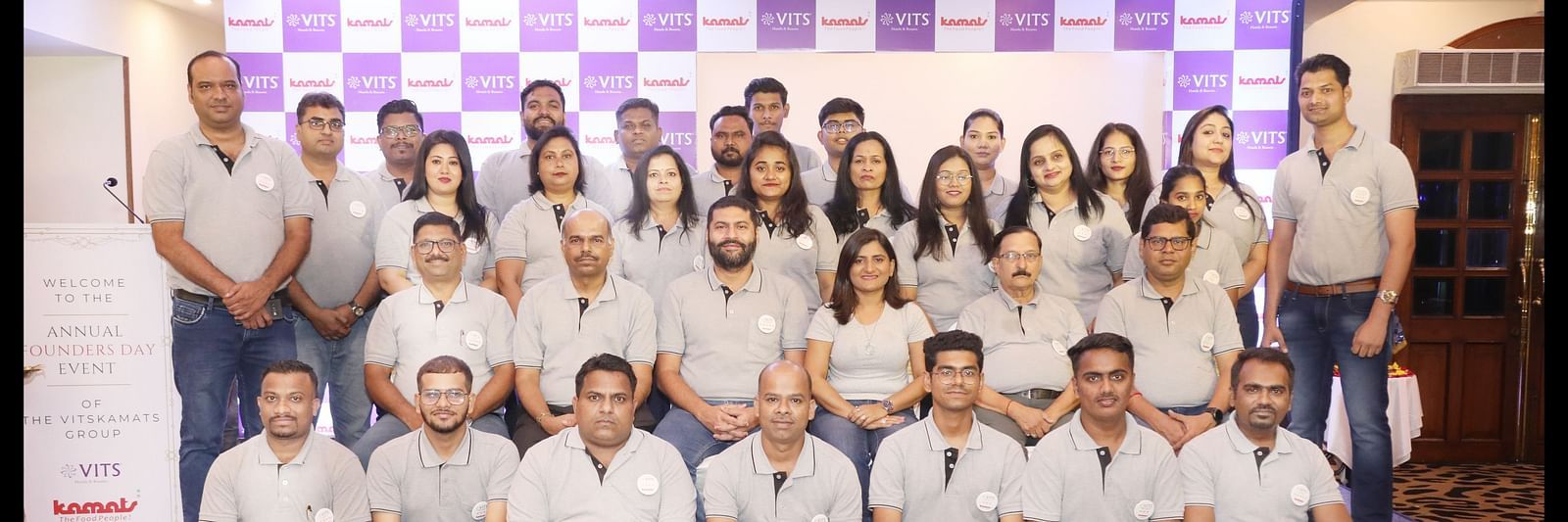 An image of a group of people posing in a stage for Kamats India and VITS Hotels and Resorts 
