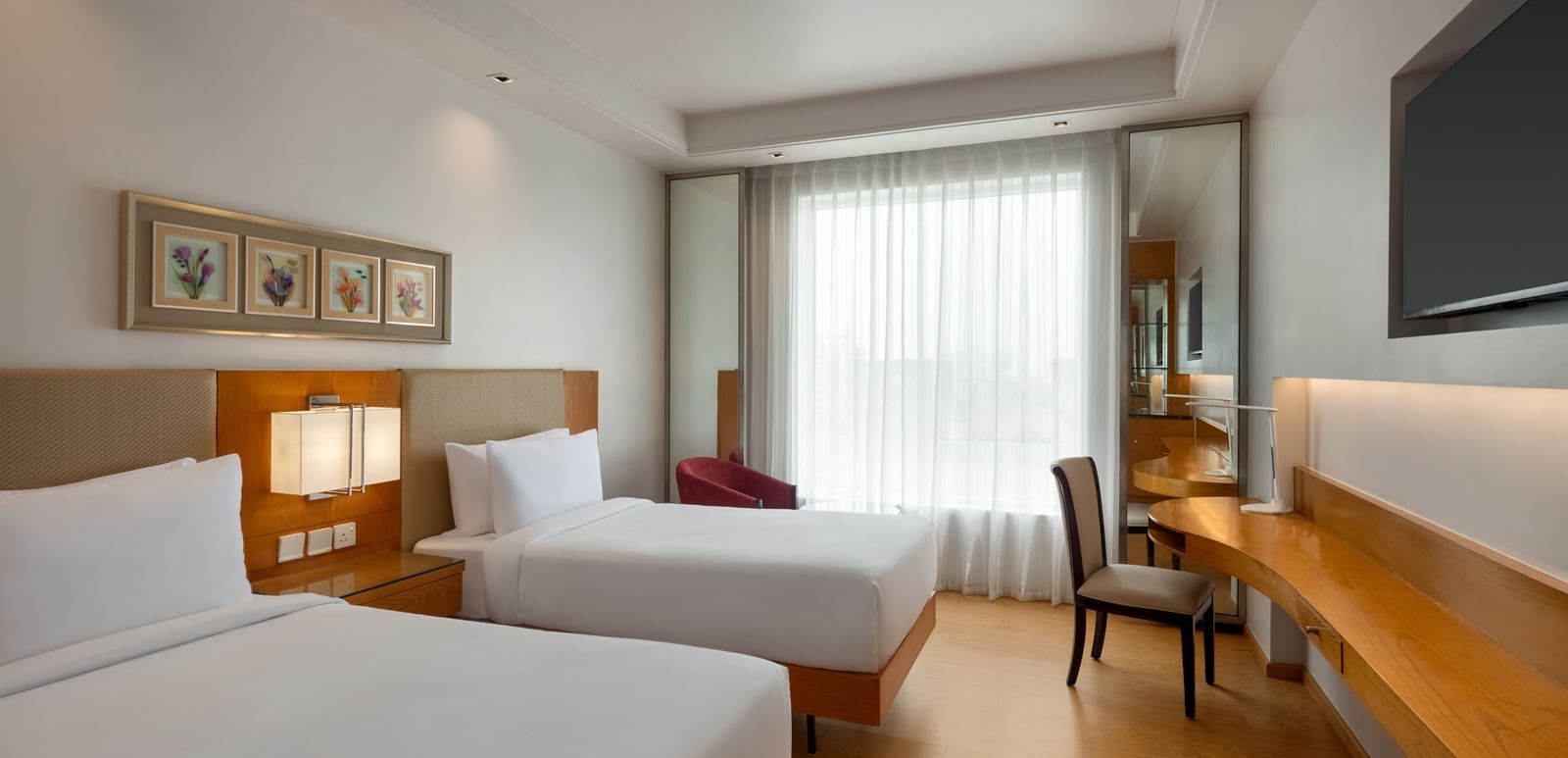 Standard guest room with twin beds and modern amenities at Ramada by Wyndham Ghaziabad Vasundhara