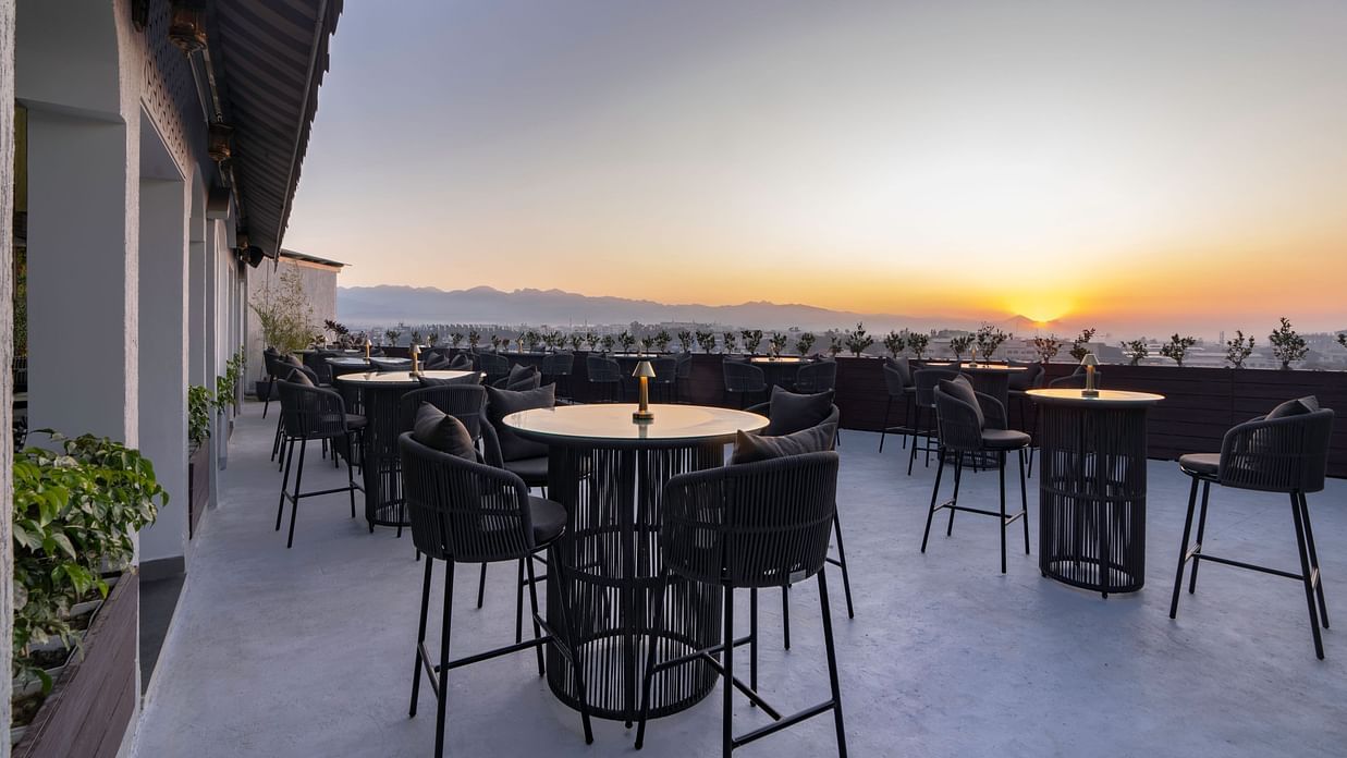 Rooftop terrace with panoramic city views at sunset.
