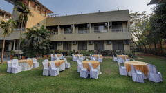Open lawn event space with round tables and resort building view at VITS Lonavala.