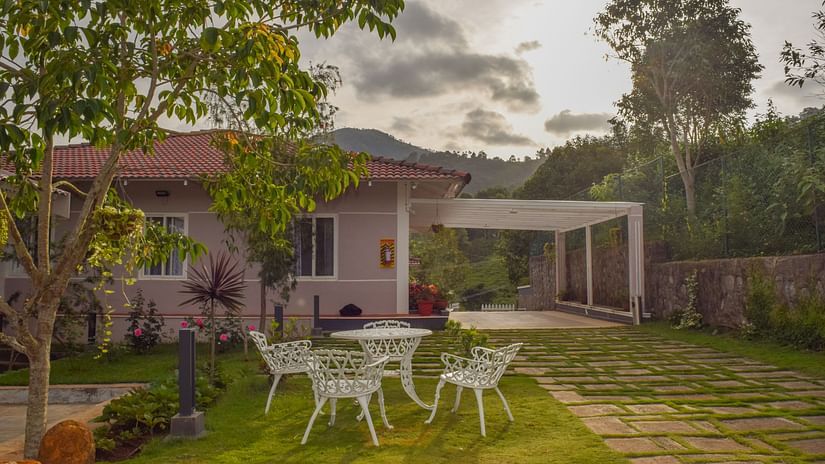 Image of lawn with a white table and chairs in the center - Ibex Stays & Trails, Kotagiri