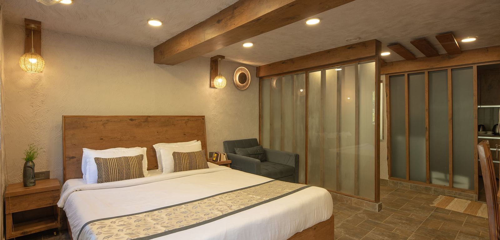 Room with double bed, wooden beams on the ceiling, and soft lighting.