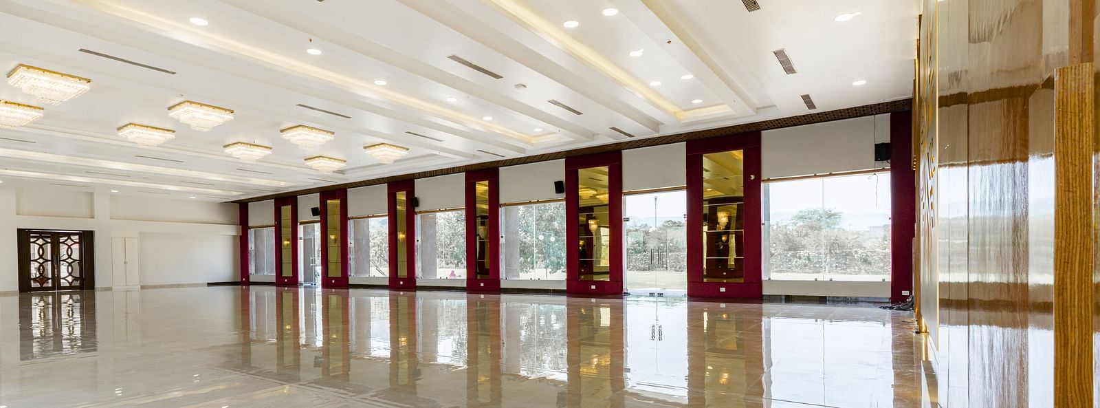 A slightly different angle of a long, empty hallway with a highly polished floor reflecting the ceiling and walls - Bamboo Saa Mulberry Resort, Pushkar